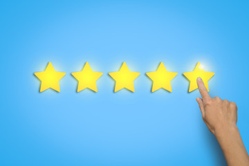 Female hand leaves a rating of five stars out of five possible o