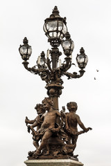 Fototapeta na wymiar Lantern of the Pont Alexandre III at a cloudy winter day in Paris 