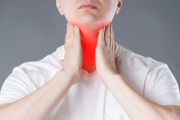 Sore throat, men with pain in neck, studio shot on gray background