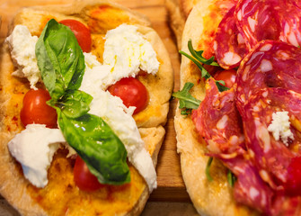 Italian focaccia with Pepperoni, basil leaf and cheese on a rustic wooden table closeup. Pizza Ready to Eat. Top view