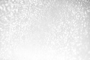 Silver Christmas background with sparkling lights. Abstract grey and white bokeh lights and stars. Festive, Holiday, Party, Christmas texture.