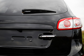 Fototapeta na wymiar Black premium city crossover, luxury SUV rear light closeup.