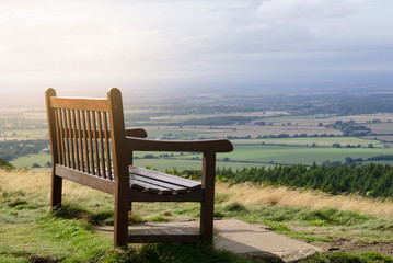 Single wooden bench on the top with beautiful view of mountain and farm view at countryside in north of England, Top view of large field in gloomy day