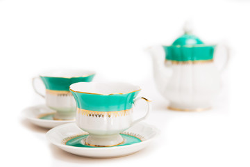 set of dishes on white background. Green indian cups and kettle
