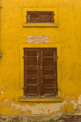 marode Fassade mit braunem Fensterladen aus Holz und Oberlicht Ladeluke eines alten Fabrikgebäudes, ailing facade with brown wooden shutter and skylight hatch of an old factory building