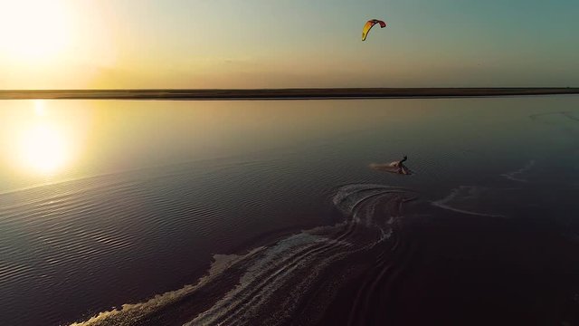 Slow shooting, calm lake where a man is engaged in kitesurfing