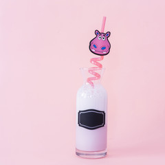 Strawberry milk/ Milkshake in jar with pink hippopotamus pipette, on pink background and with writing space