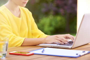 Cropped shot of a woman's hand typing on laptop