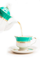 Green indian cup of tea and kettle on white background. Isolated on white