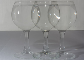 A glass with water in different light and with its own copies like a shadow