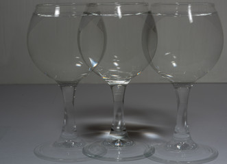 A glass with water in different light and with its own copies like a shadow