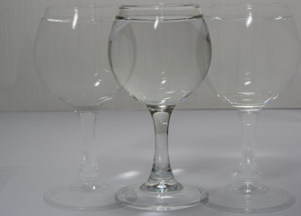 A glass with water in different light and with its own copies like a shadow