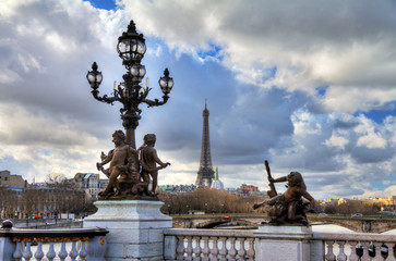 Fototapeta na wymiar Beautiful view of a lantern on the Pont Alexandre III in Paris, with the Eiffel tower in the background, on a cloudy winter day 