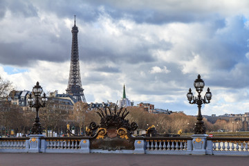 Fototapeta na wymiar Beautiful view of a lantern on the Pont Alexandre III in Paris, with the Eiffel tower in the background, on a cloudy winter day 