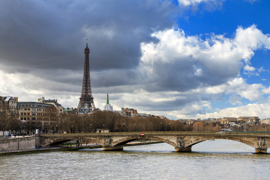 Beautiful view of the river Seine in Paris, with the Eiffel tower in the background, on a cloudy winter day 
