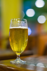 Cold beer in a stemmed glass on a blurred bokeh background