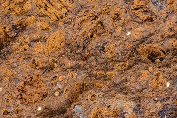 Colorful abstract background of volcanic tuff rock. Warm colored volcanic tuff often used for decoration in a garden.