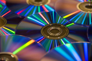 Many musical compact discs with a rainbow spectrum of colors as a bright background