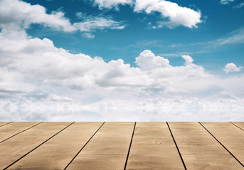 wooden table top with blue sky reflective on water