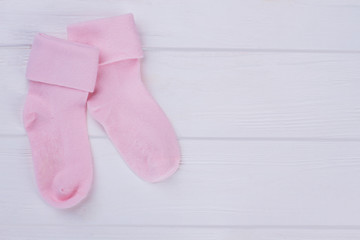 Pair of woolean pink baby socks with copyspace.