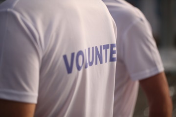 Men in T-shirts with the inscription Volunteers at a sporting public mass event competition