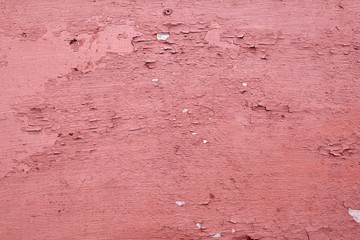 Red brown wooden surface with peeling paint.