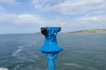 Coin operated binocular on the summer beach, tourist scene in Spain