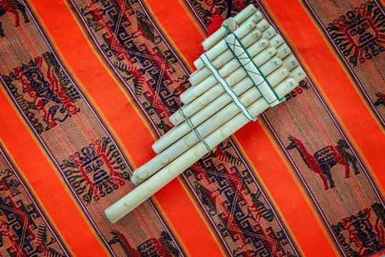 Pan flute on traditional andean fabric background