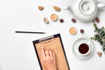 A woman hands writing on empty book note, diary, spread mockup, top view, studio. Cup of coffee break.