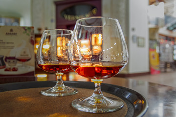 Glasses with cognac on tray. Vintage collection, alcoholic drinks set.