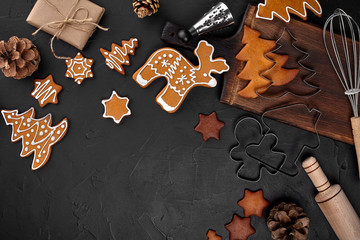 Christmas homemade gingerbread cookies, spices and cutting board on dark background with copy space for text top view. New year and christmas postcard
