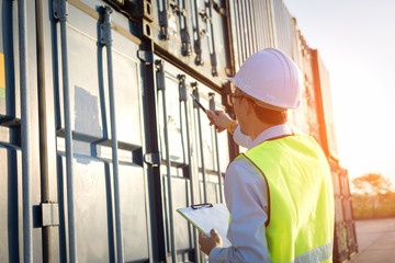 foreman control loading Containers box from Cargo freight ship at harbor