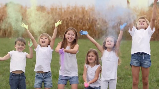 Funny childhood outdoors children cheer throw toss up holi colors powder paint