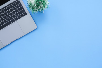 Office desk working space - Flat lay top view copy space of a working space with laptop placing on a blue pastel background with blank space. Pastel blue color copy space working desk concept.