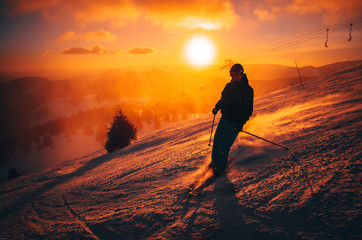 Fototapeta na wymiar DONOVALY, SLOVAKIA, 5. JANUARY, 2017: Skier in Jasna ski resort, sunset light in background