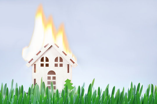 Safety fire concept. Toy house with flames. Burning model house.
