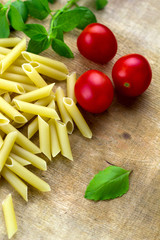pasta,tomatoes,basil on a wooden cutting board