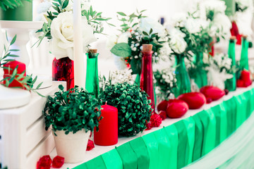 Soccer and pole sport dancer wedding decor in Eco rustic style with green ribbons, red candles, bottles, white flowers and green leaves.