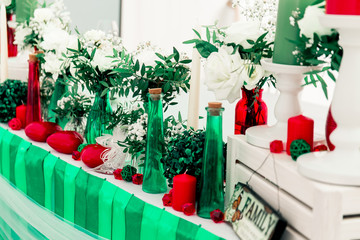 Soccer and pole sport dancer wedding decor in Eco rustic style with green ribbons, red candles, bottles, white flowers and green leaves.