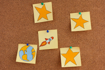 Post it Notes with planet Earth and Space Rocket with Stars on bulletin board