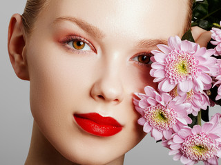 Beauty face. Makeup artist concept. Cute girl applies red lipstick . Beautiful woman face. Make-up...