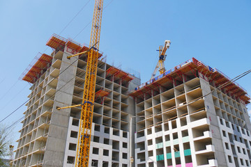 Fototapeta premium Construction site with cranes and building. Two cranes near building.