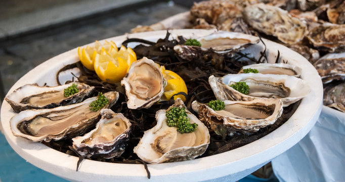 Fresh Oysters With Lemon On Plate. Fish Market In France.