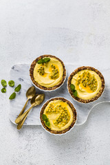 vegan raw mini tarts from nuts and dates with cashew cream from mango purée with lime juice and...