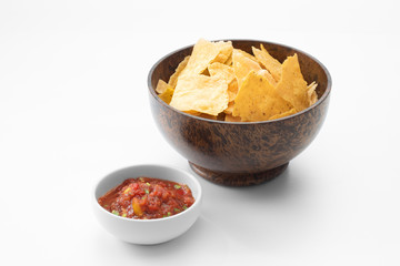 close up view of nice red salsa and corn chips on white background.