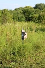 A old wooden birdhouse in the tall grass prairie.