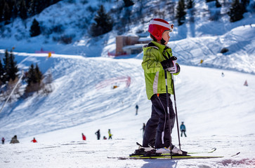 Fototapeta na wymiar Little skier on the snow slopes in the high mountains