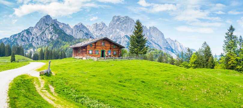 Idyllic mountain scenery with wooden cabin in the Alps in summer