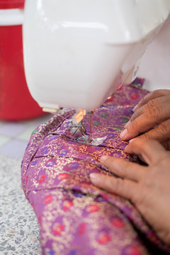 Female hands on sewing machine