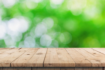 Empty wooden table top and green bokeh display montage for product with space.